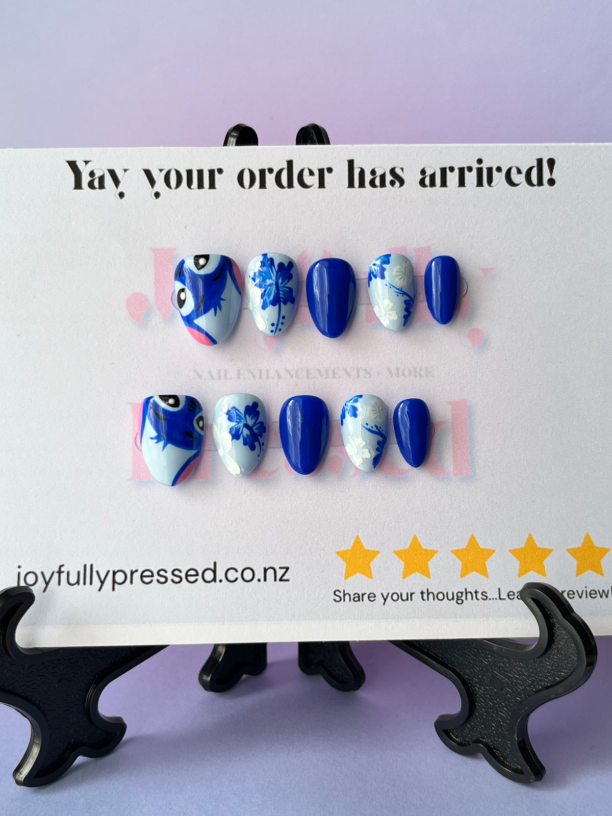 A set of Stitch themed press-on nails displayed on a card that reads 'Yay your order has arrived!' with the website joyfullypressed.co.nz
