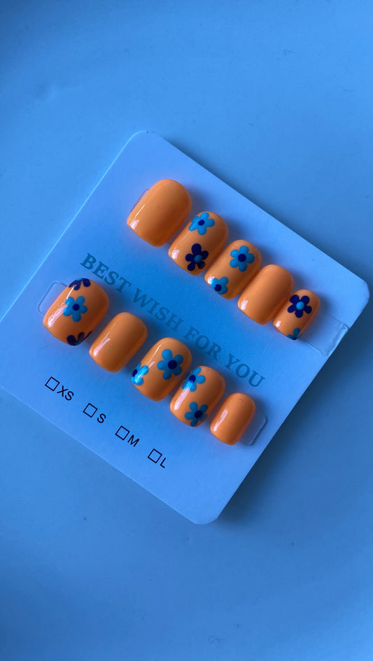 Kids orange base presson nails with dark and light blue flowers 